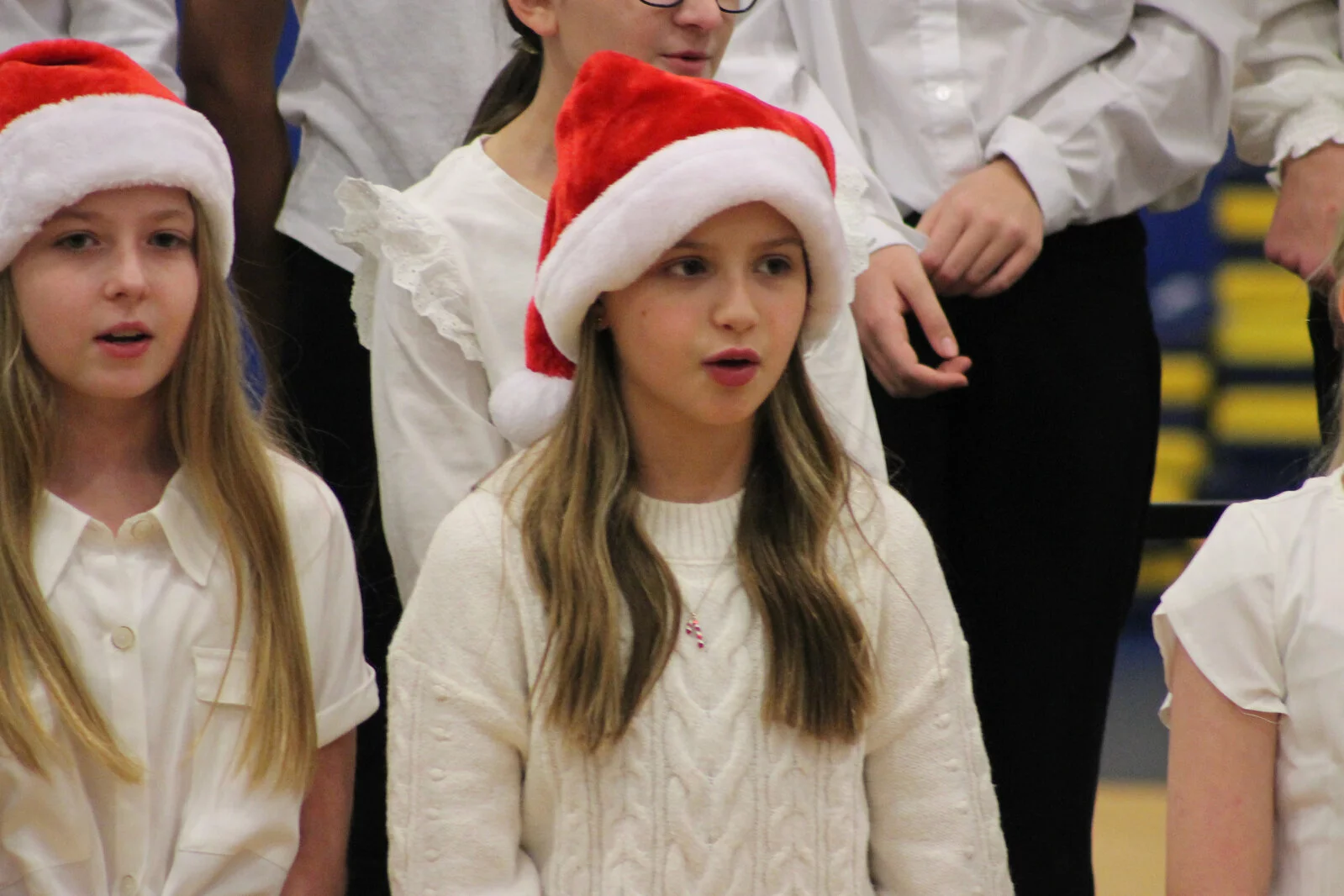 Close up of student singing with santa hat on