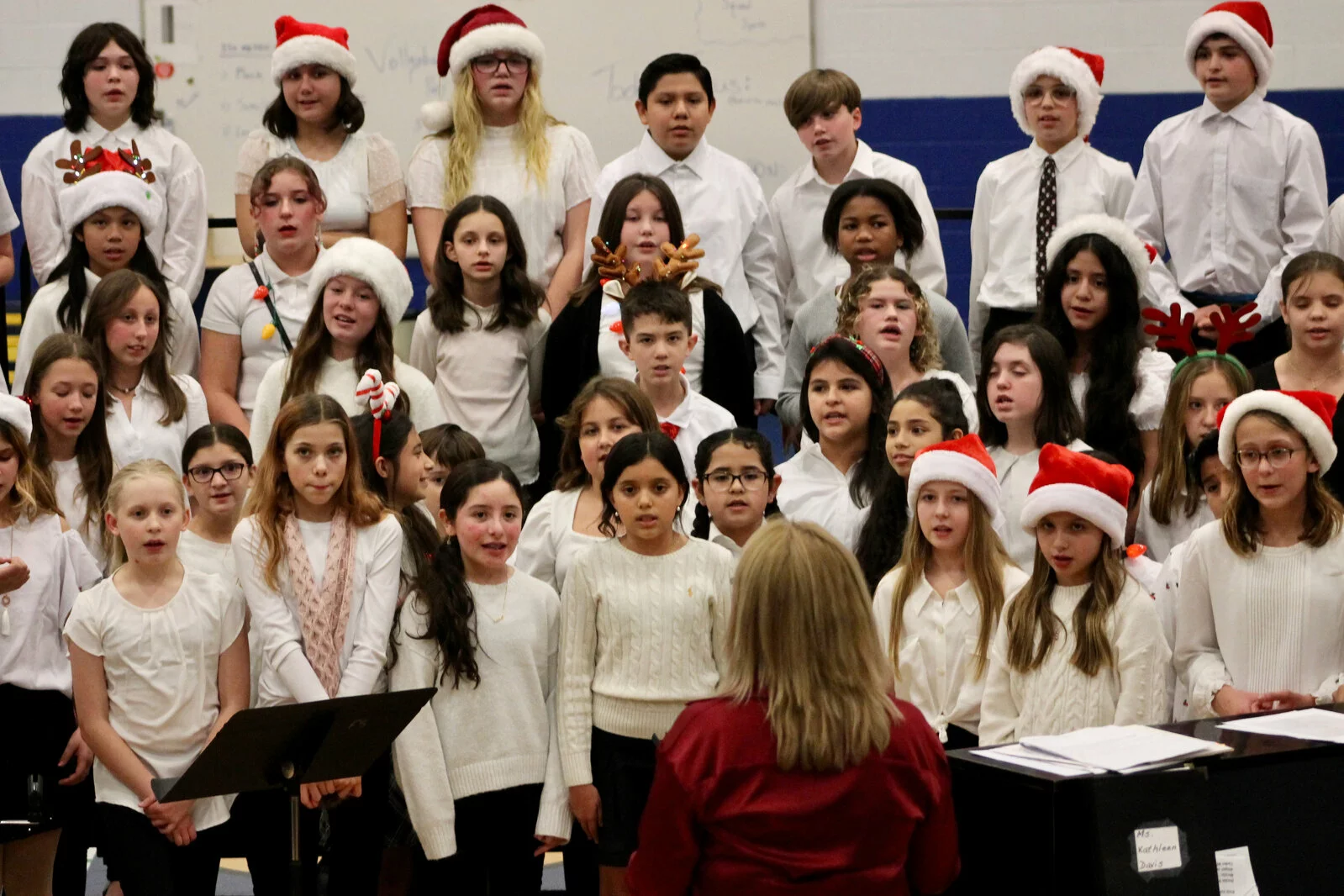 group of students singing with teacher Kathleen Davis in front